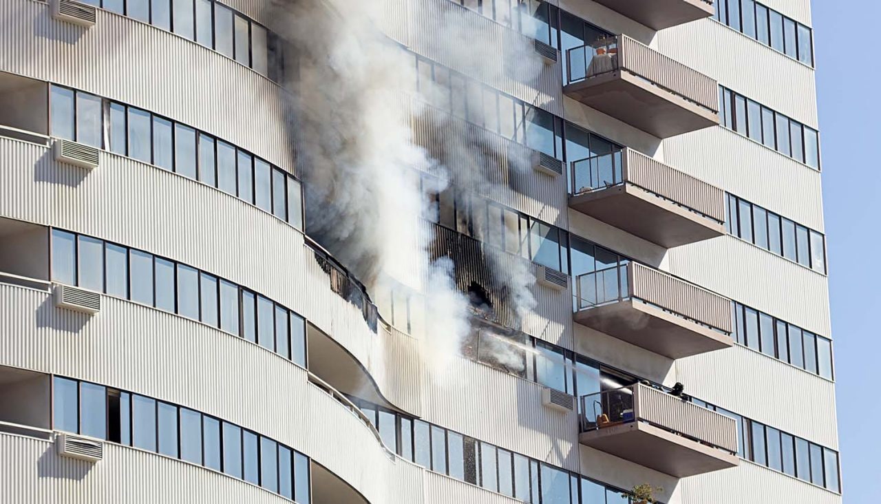 532129585 Firefighters extinguish the blaze by pouring water onto the fire from the nearby balcony.